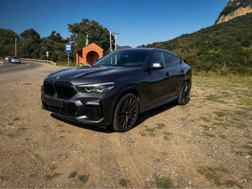 BMW X6 M50i — вид спереди в три четверти в горах