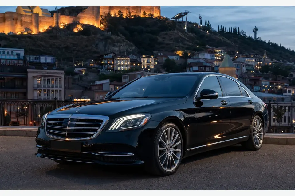 Чёрный Mercedes-Benz S 450 на фоне вечернего Тбилиси