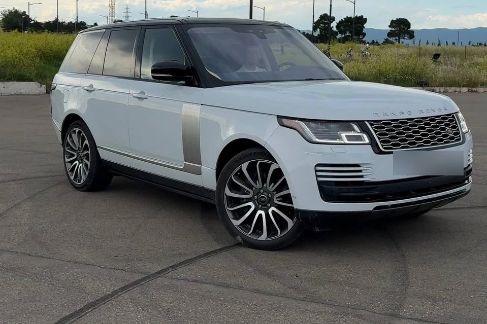 Белый Range Rover Vogue Autobiography на открытой площадке за городом